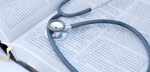 A stethoscope on top of a book.