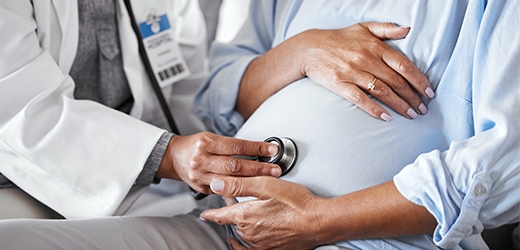 Doctor verificando al bebe de la paciente con un estetoscopio. 