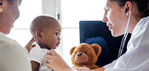 Doctor checking baby with a teddy bear.