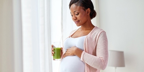 A pregnant African-American female smiling.