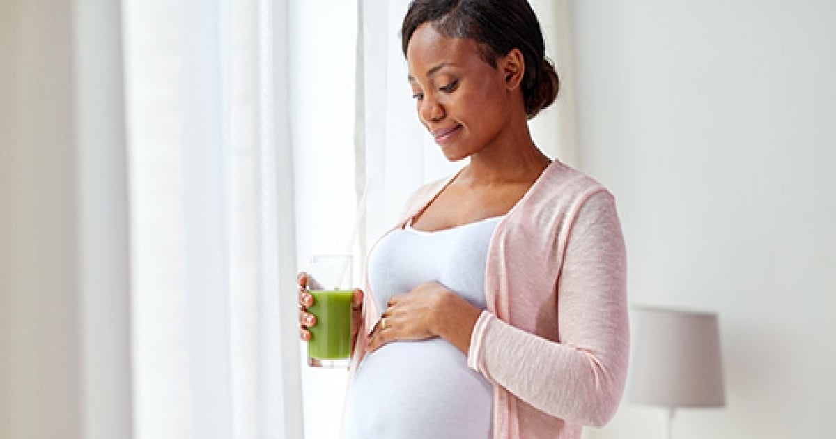 A pregnant African-American female smiling.